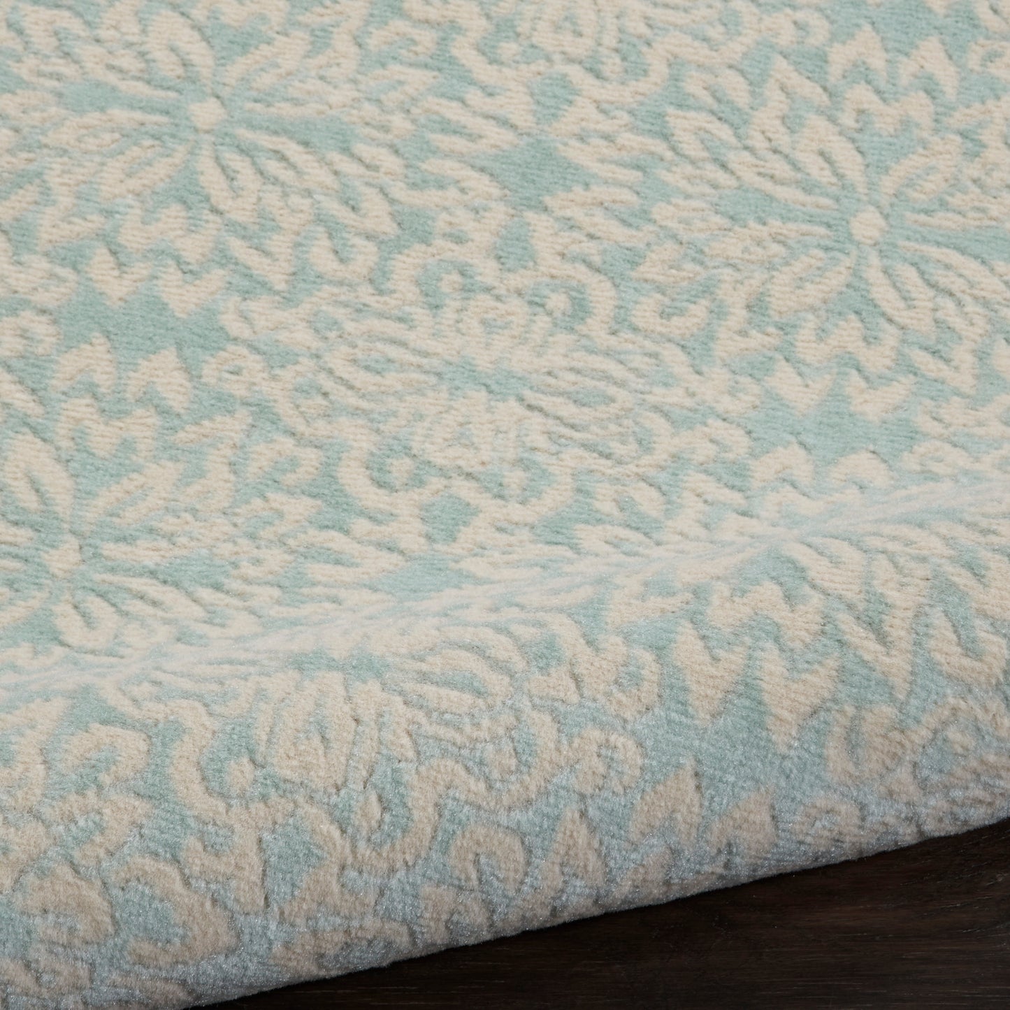 Light blue terry rug with cream damask pattern, folded edge visible, 7' runner.