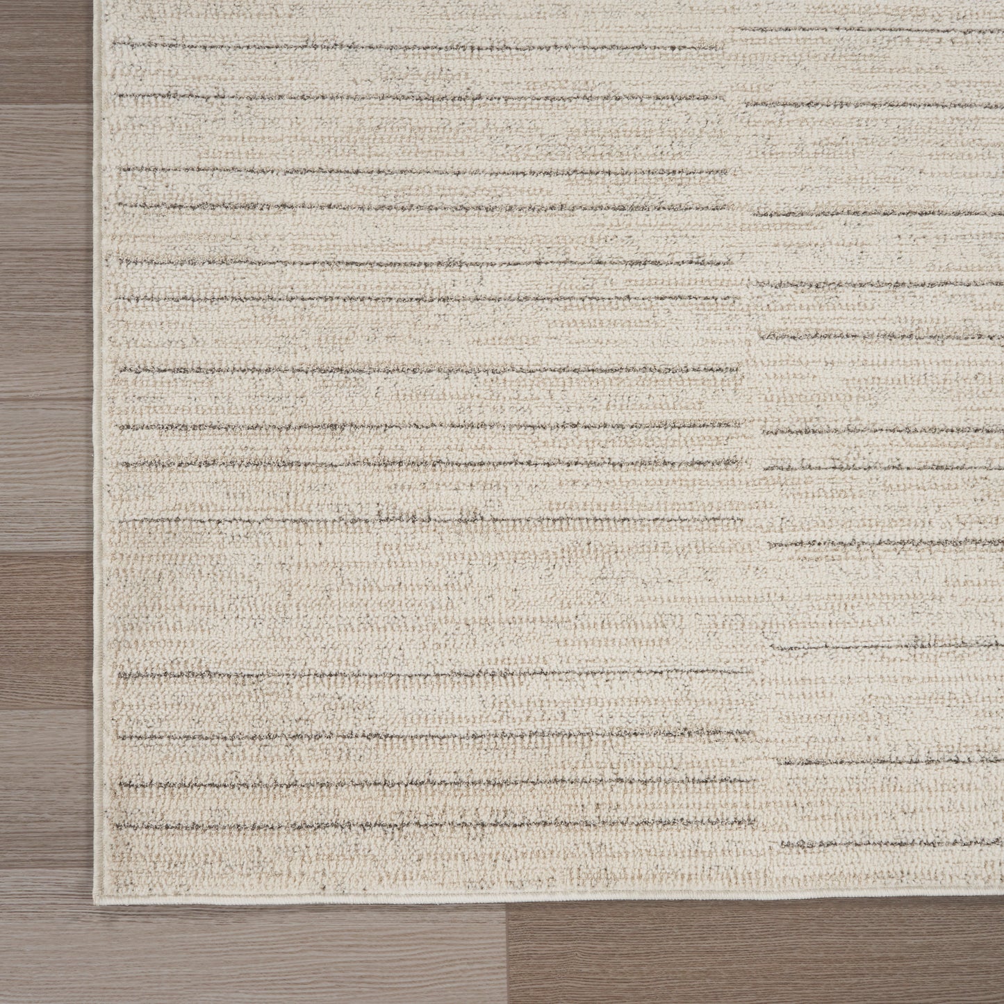 Beige textured flatweave runner rug with cream & taupe horizontal stripes on wood floor.