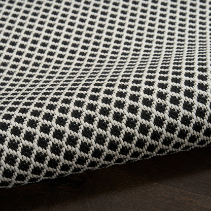 Black and white woven rug featuring a geometric lattice pattern and textured fabric for floor use.