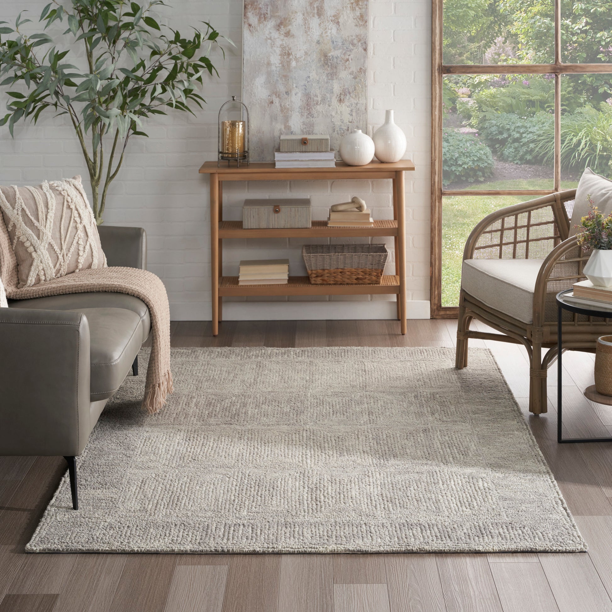 Light gray textured area rug with subtle geometric pattern in a cozy modern living room.