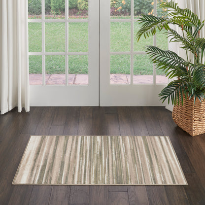 Rectangular striped beige-taupe rug on dark hardwood floor beside glass-paned French doors and a wicker plant basket.