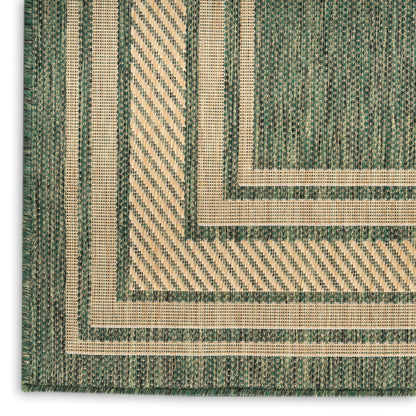 Green and natural beige flatwoven rug with concentric rectangular borders and diagonal striped textures; rustic geometric style.