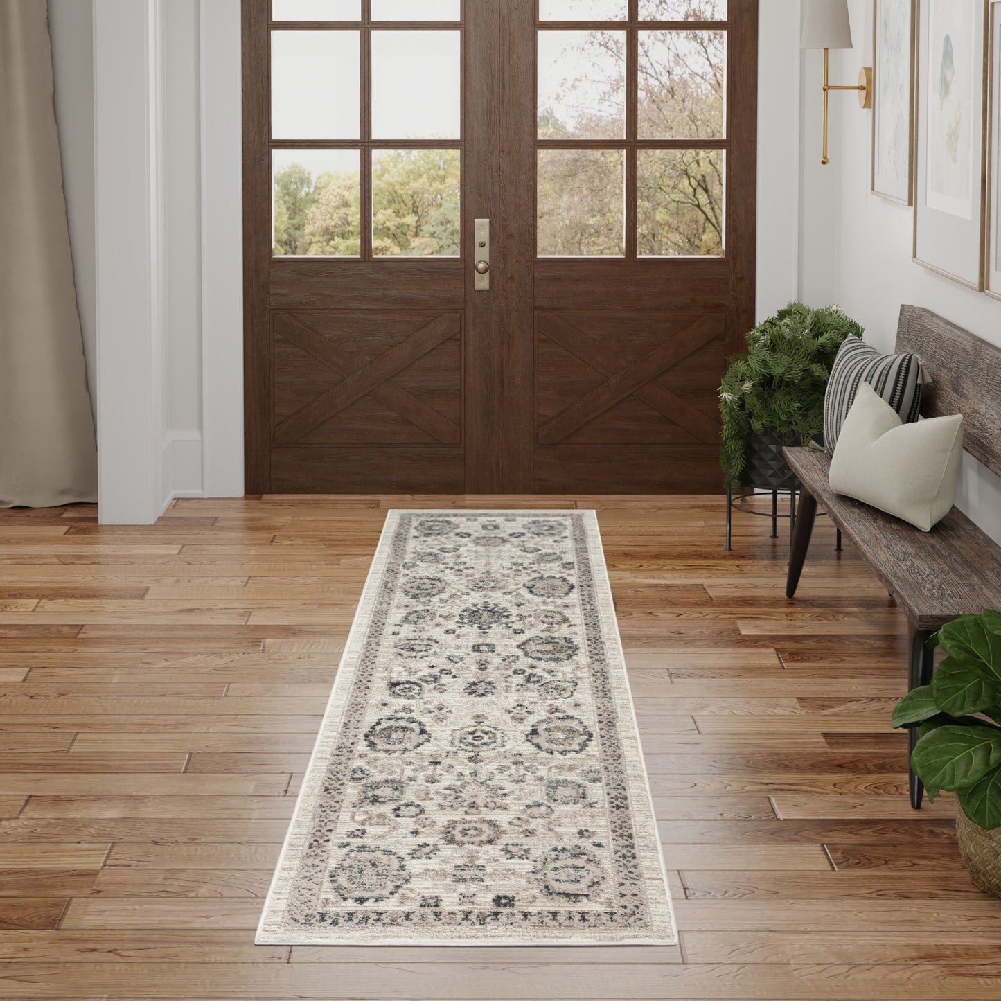 Entryway scene featuring double dark wood doors and a long beige-gray traditional floral medallion runner on hardwood floor.