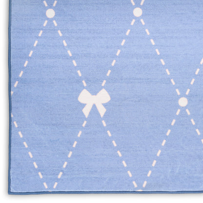 Blue rug with white dashed argyle diamonds and a small white bow at center.