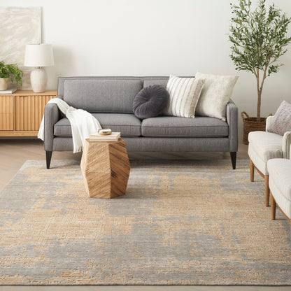 Gray mid-century sofa with cushions and a cream throw, geometric wooden coffee table, beige rug, plant and sideboard.