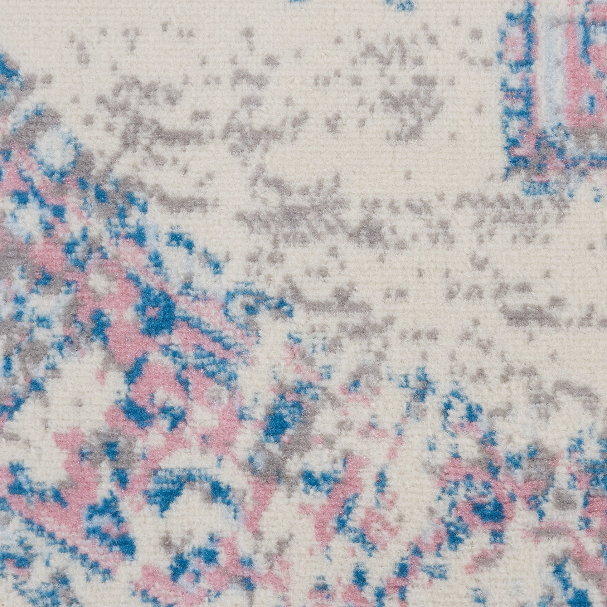 Close-up of cream woven rug with pink, blue and gray abstract floral pattern (round, 4' diameter).