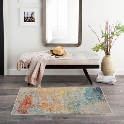 Modern entryway with beige tufted bench, straw hat, blush throw, rounded mirror, colorful abstract rug, vase with branches.