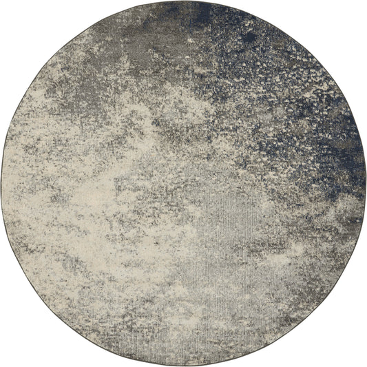 Round rug with abstract distressed gradient in beige, cream, gray and navy, textured contemporary style.