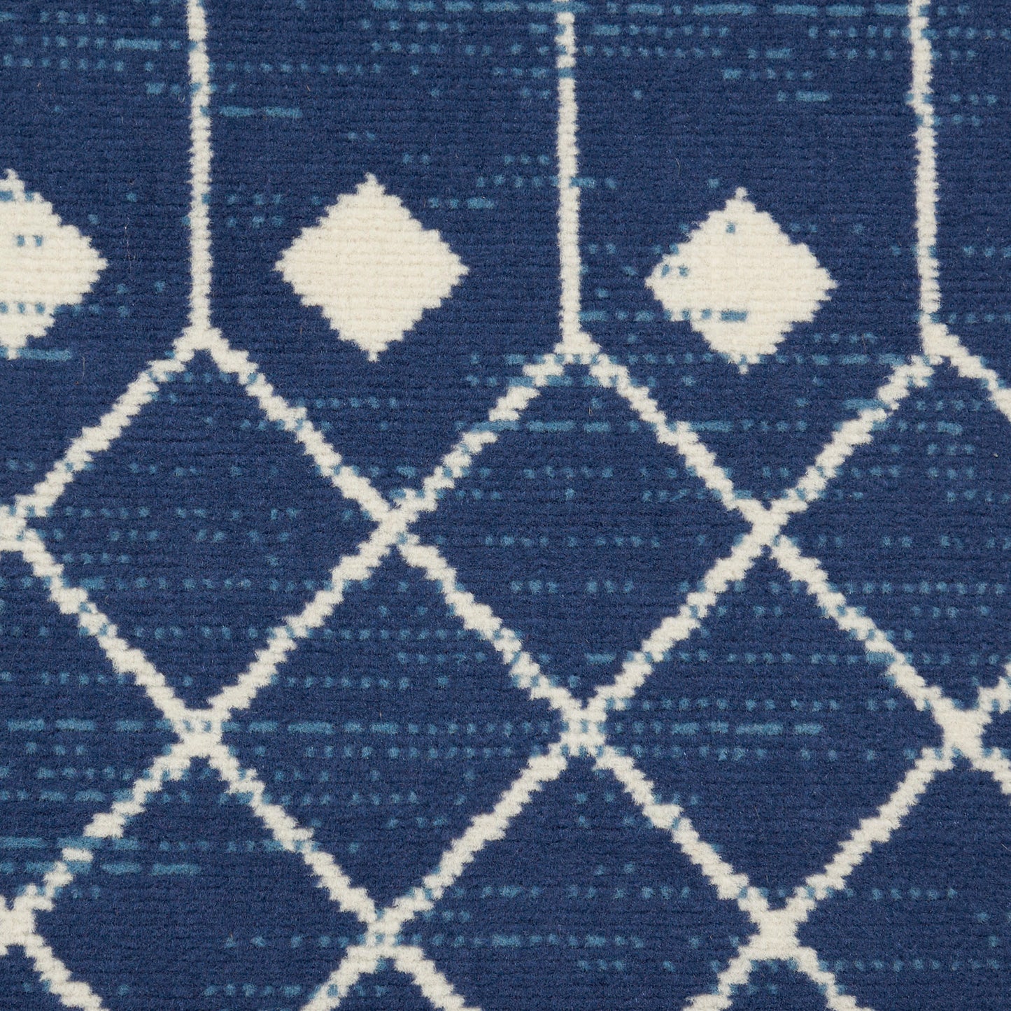 Navy blue rug with white geometric diamond lattice pattern.
