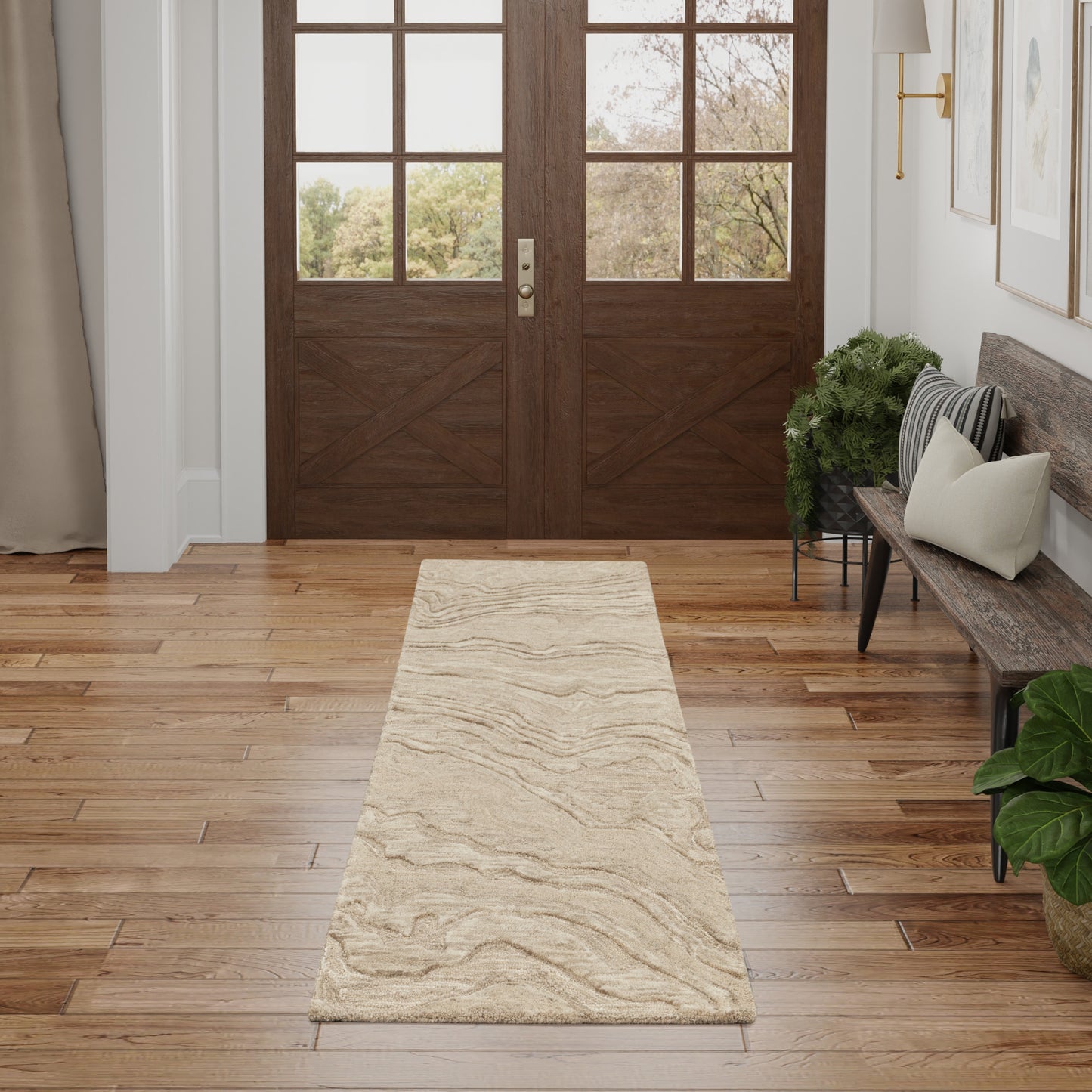 Neutral beige runner rug with subtle marbled waves on a wooden foyer floor beside a bench and double doors.