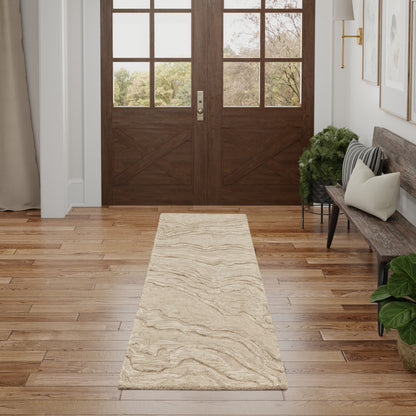Neutral beige runner rug with subtle marbled waves on a wooden foyer floor beside a bench and double doors.