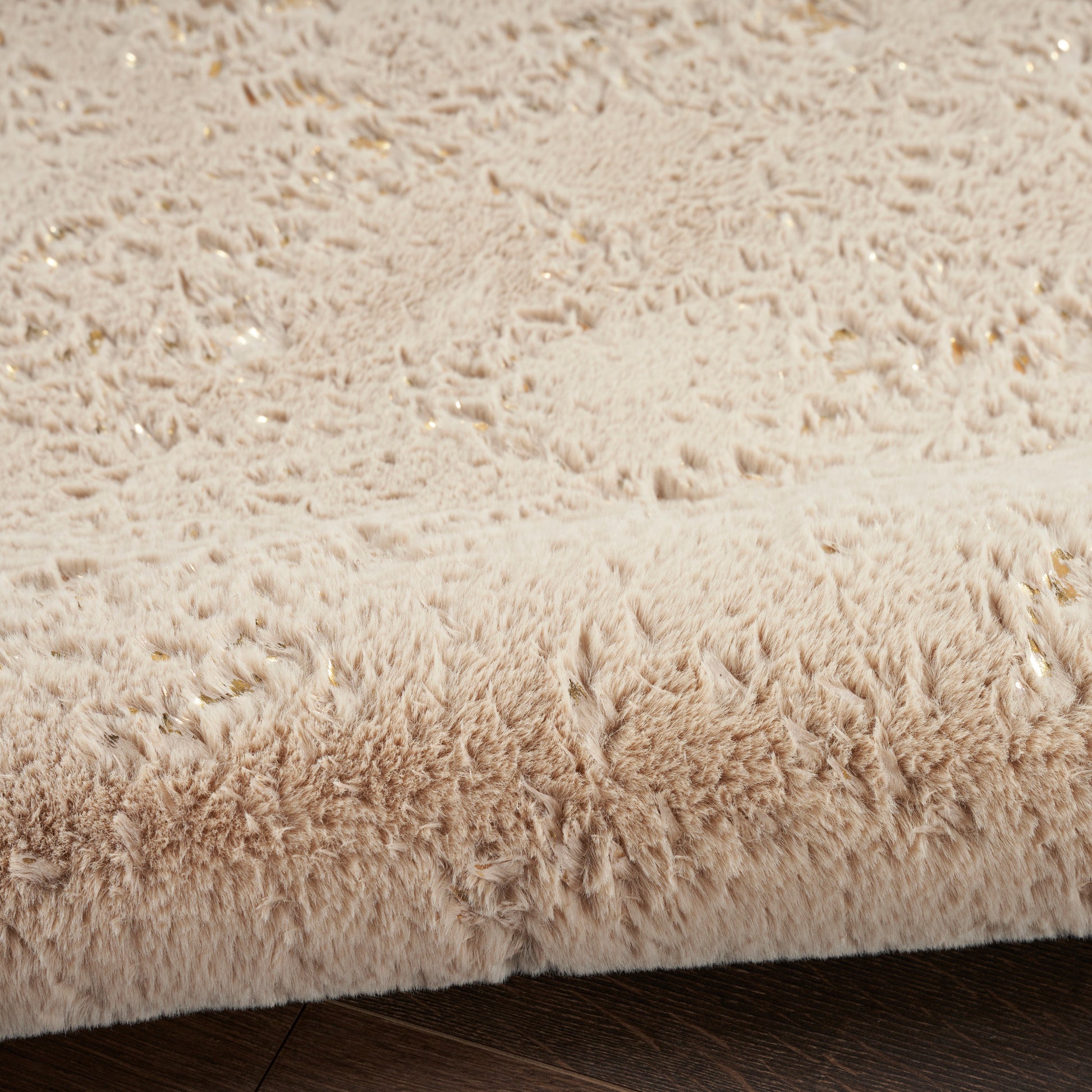 Beige shag rug with dense, fluffy pile on dark wood floor; cozy modern living room accent.