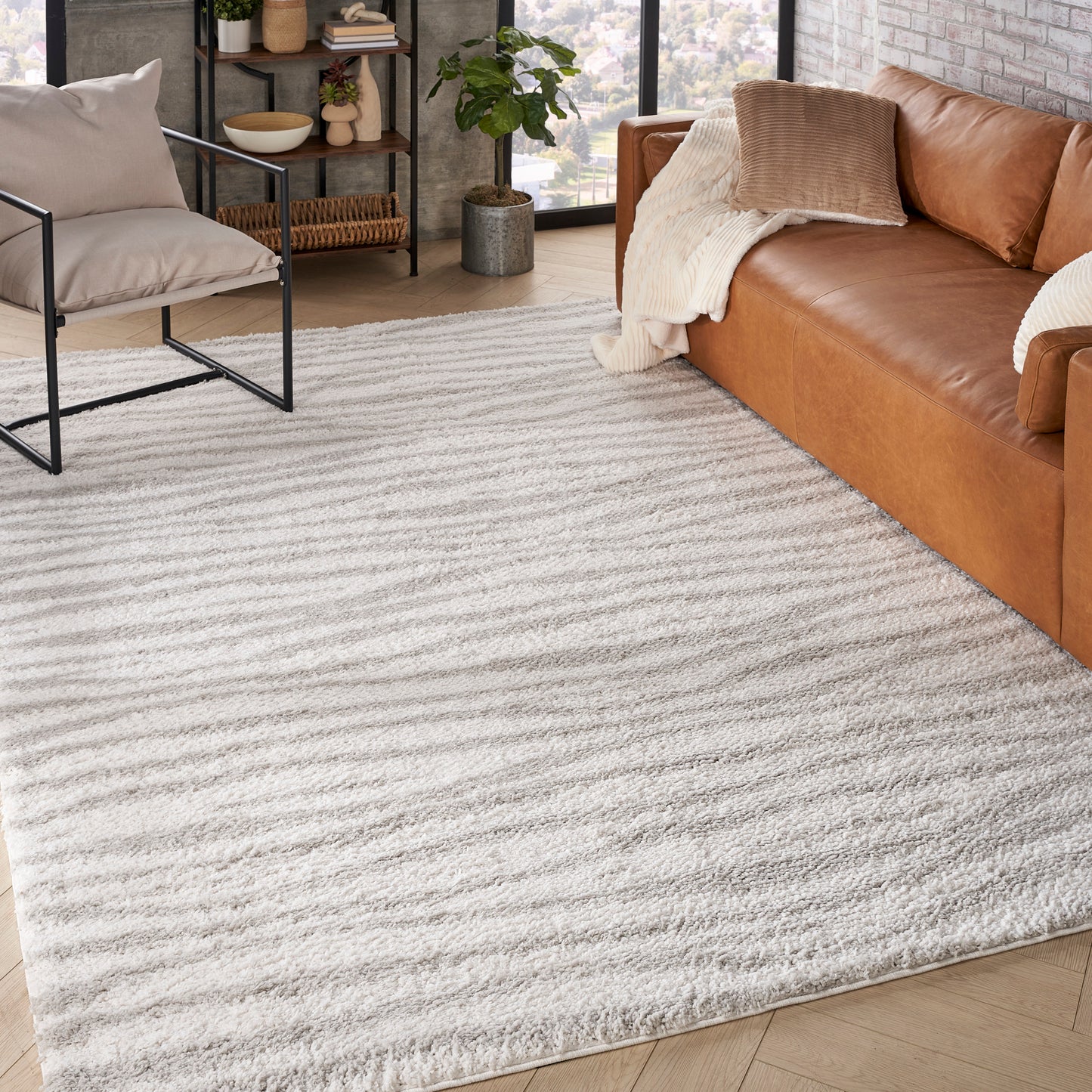 Light gray plush shag rug with subtle stripes, perfect for a modern living room under a sofa & chairs.