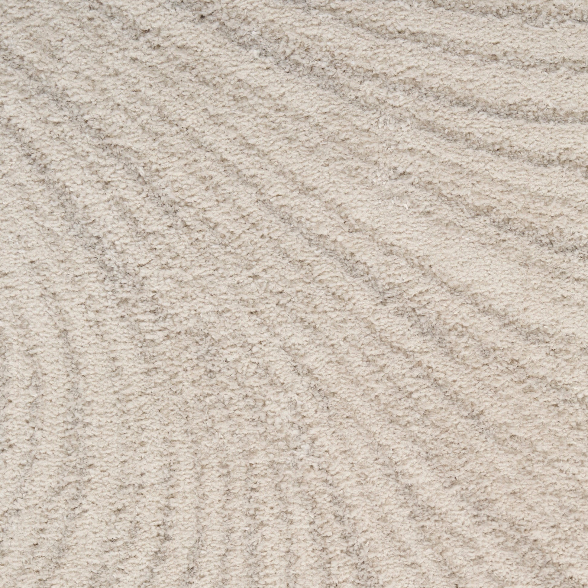 Close-up of beige woven rug fibers with a subtle texture and fine pile.