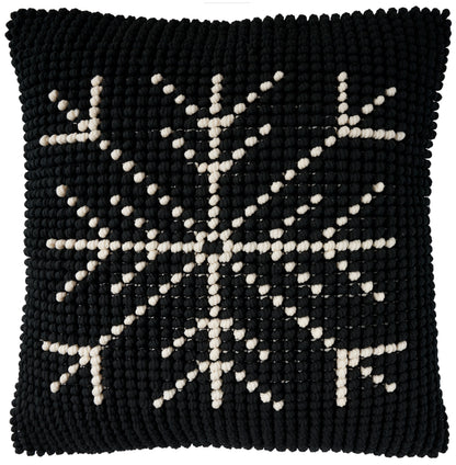 Black square knitted throw pillow with ivory snowflake motif and chunky textured surface, 20 x 20 inches.