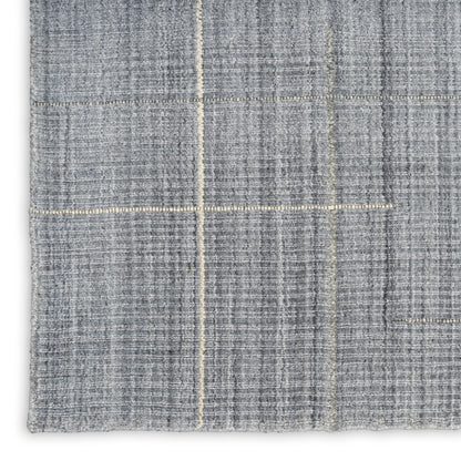 Grey woven rug with cream grid lines; textured, thick fabric, folded corner.