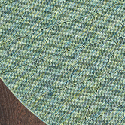 Round teal-blue denim-style rug with lime-green diagonal diamond quilting on wooden floor