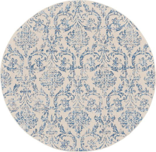Round beige area rug with blue damask floral pattern and ornamental scrollwork.