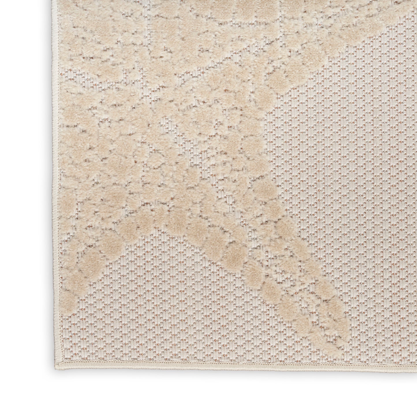 Beige outdoor runner rug with a raised leaf motif over lattice honeycomb texture and bound edge.