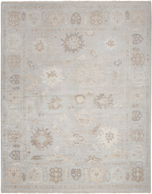 Distressed pale blue oriental area rug with beige floral medallions and ornate border; soft, low-contrast vintage look.