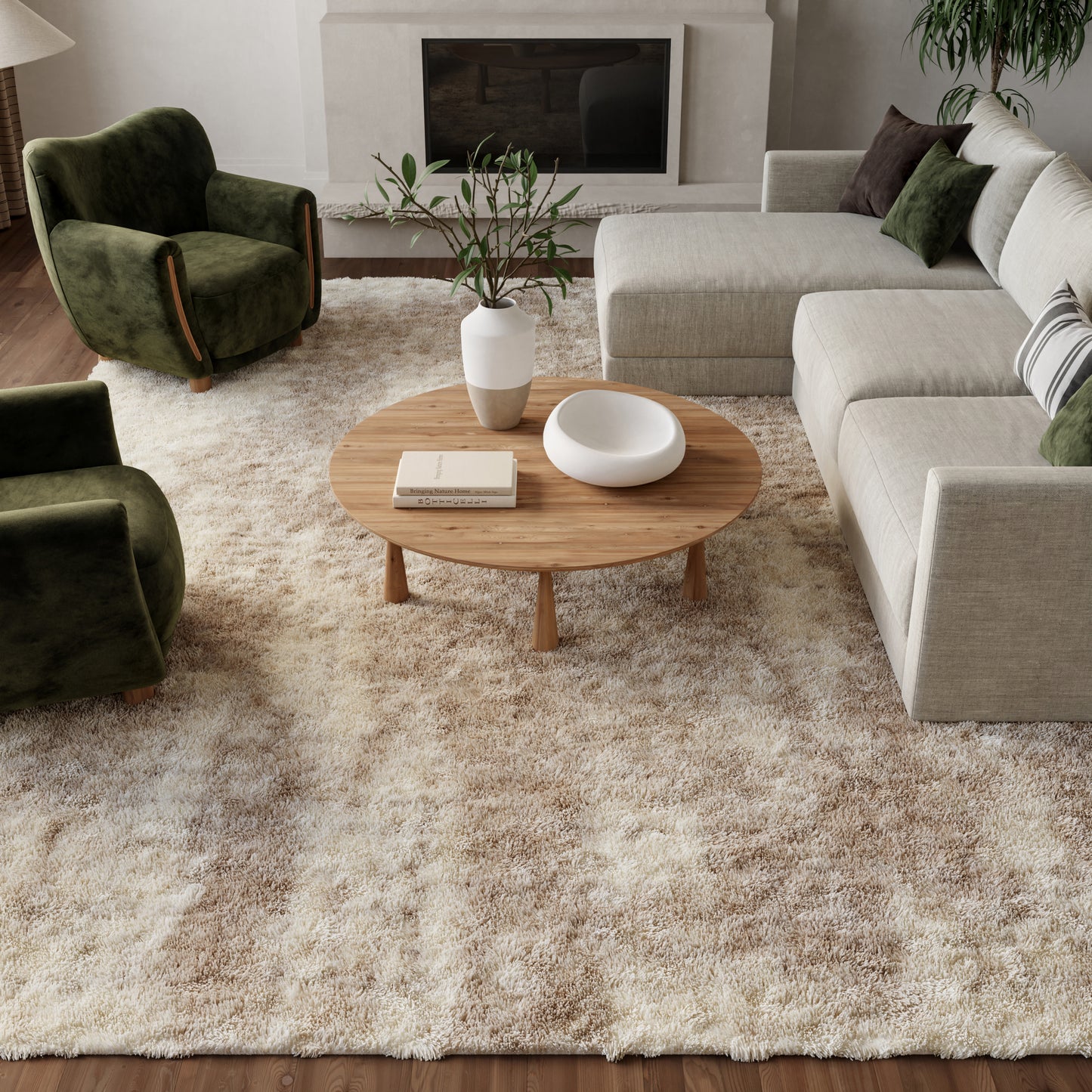 Neutral living room with beige sectional, dark green velvet chairs, round wood coffee table, white vase, shaggy beige rug.