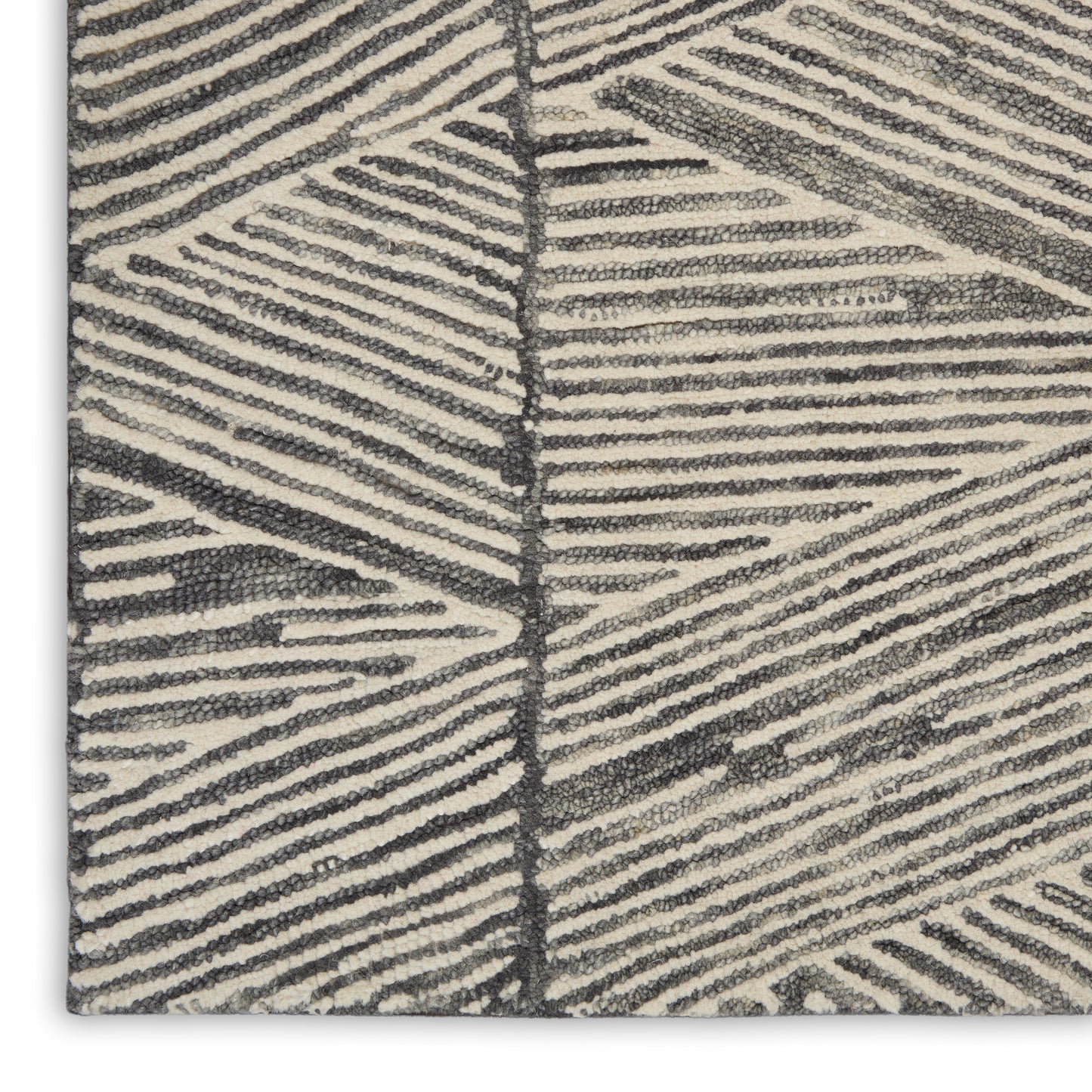 Beige textured rug close-up with dark gray palm-leaf pattern; loop pile, modern geometric style.