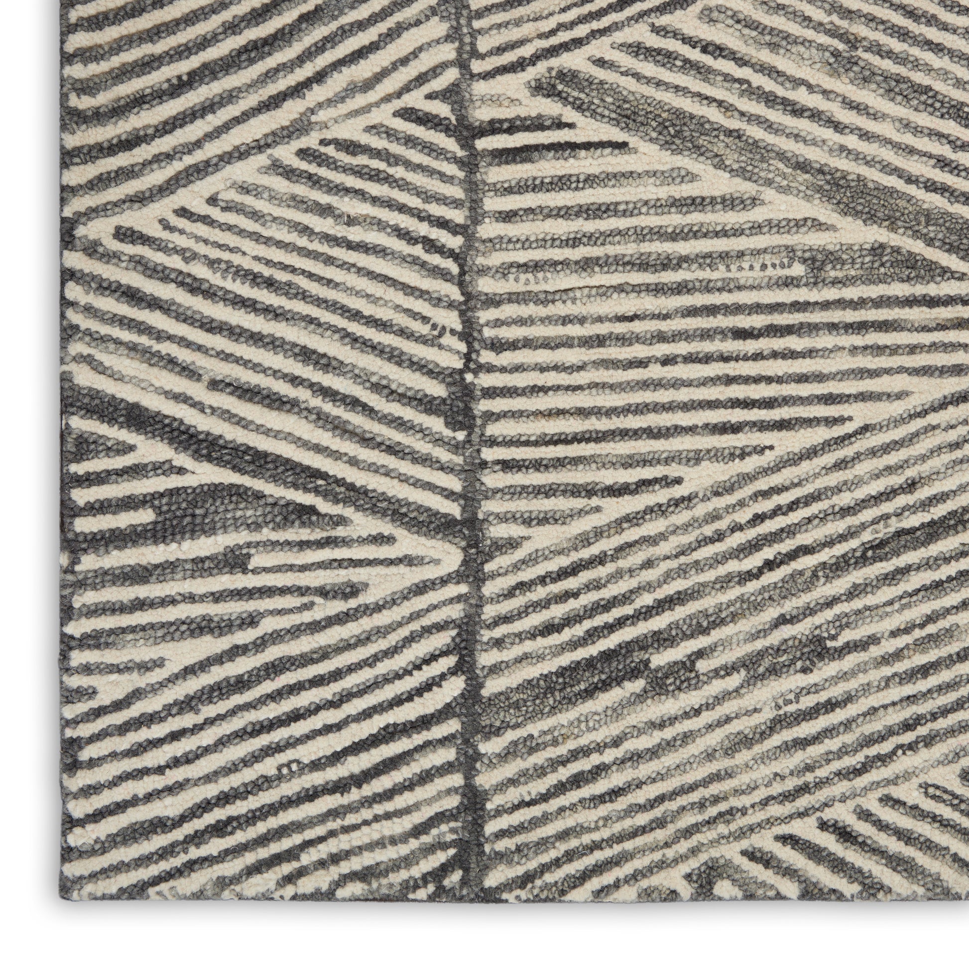 Beige textured rug close-up with dark gray palm-leaf pattern; loop pile, modern geometric style.