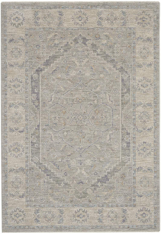Distressed vintage-style oriental rug in ivory-gray with pale blue border, central medallion and floral motifs.