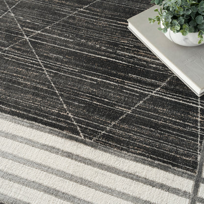 Charcoal rug with white diagonal grid pattern and cream striped border, paired with books and a potted plant.