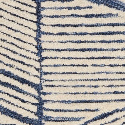 Close-up of cream shag rug with navy blue striped pattern; tufted, soft pile for modern home decor.