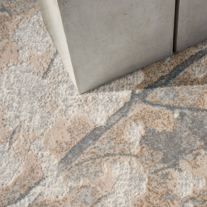 Rectangular area rug with a soft pile in beige, gray, peach and blue abstract floral pattern.