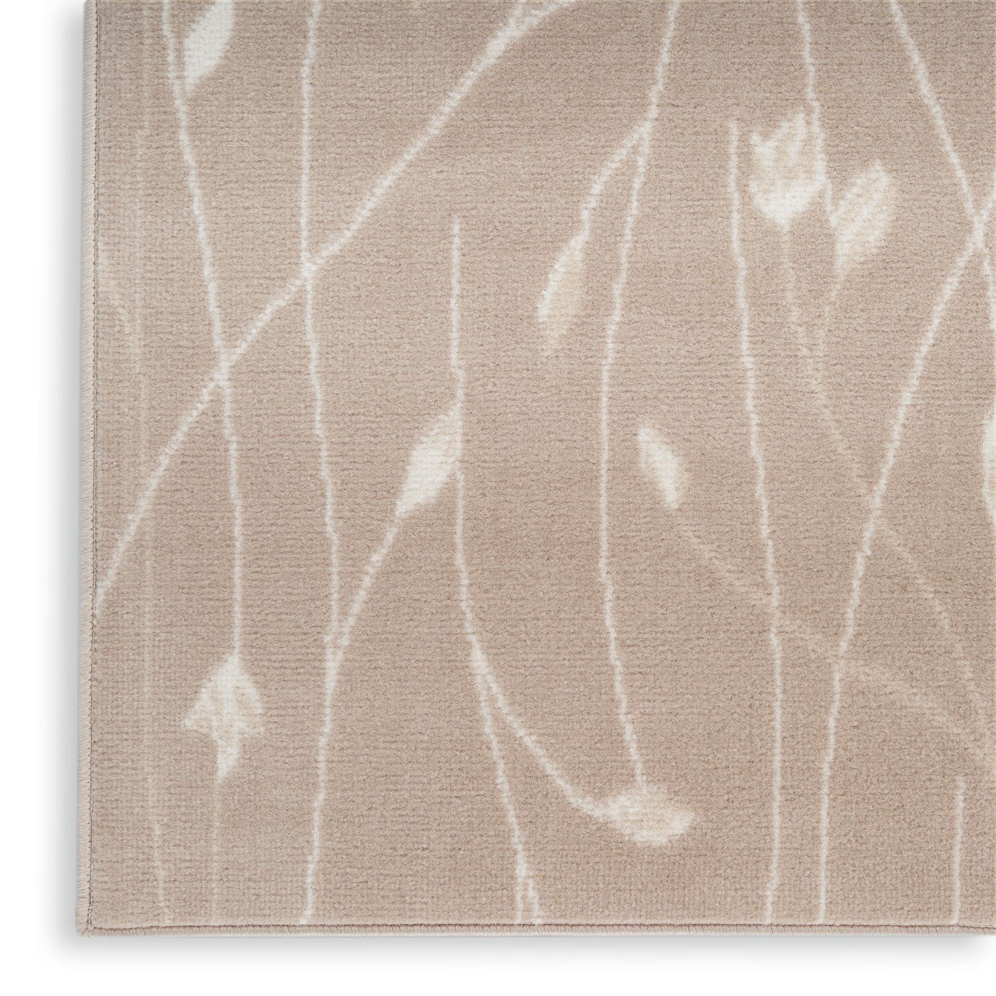 Beige plush rug with white abstract botanical pattern of slender stems and small leaf shapes.