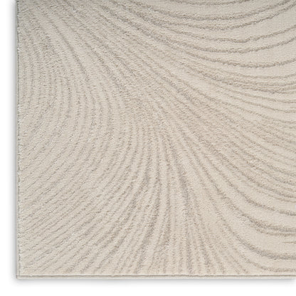 Beige textured rug with soft pile and subtle curved wave pattern.