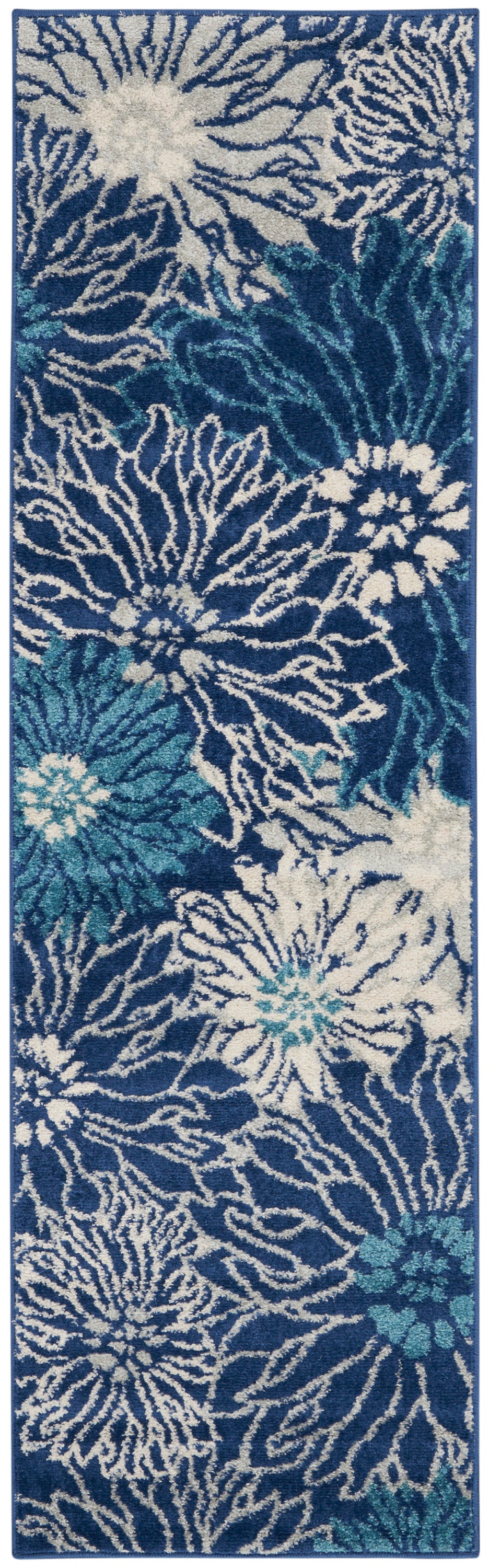 Rectangular navy blue shag rug with large white and teal floral bursts; tufted, modern coastal style.