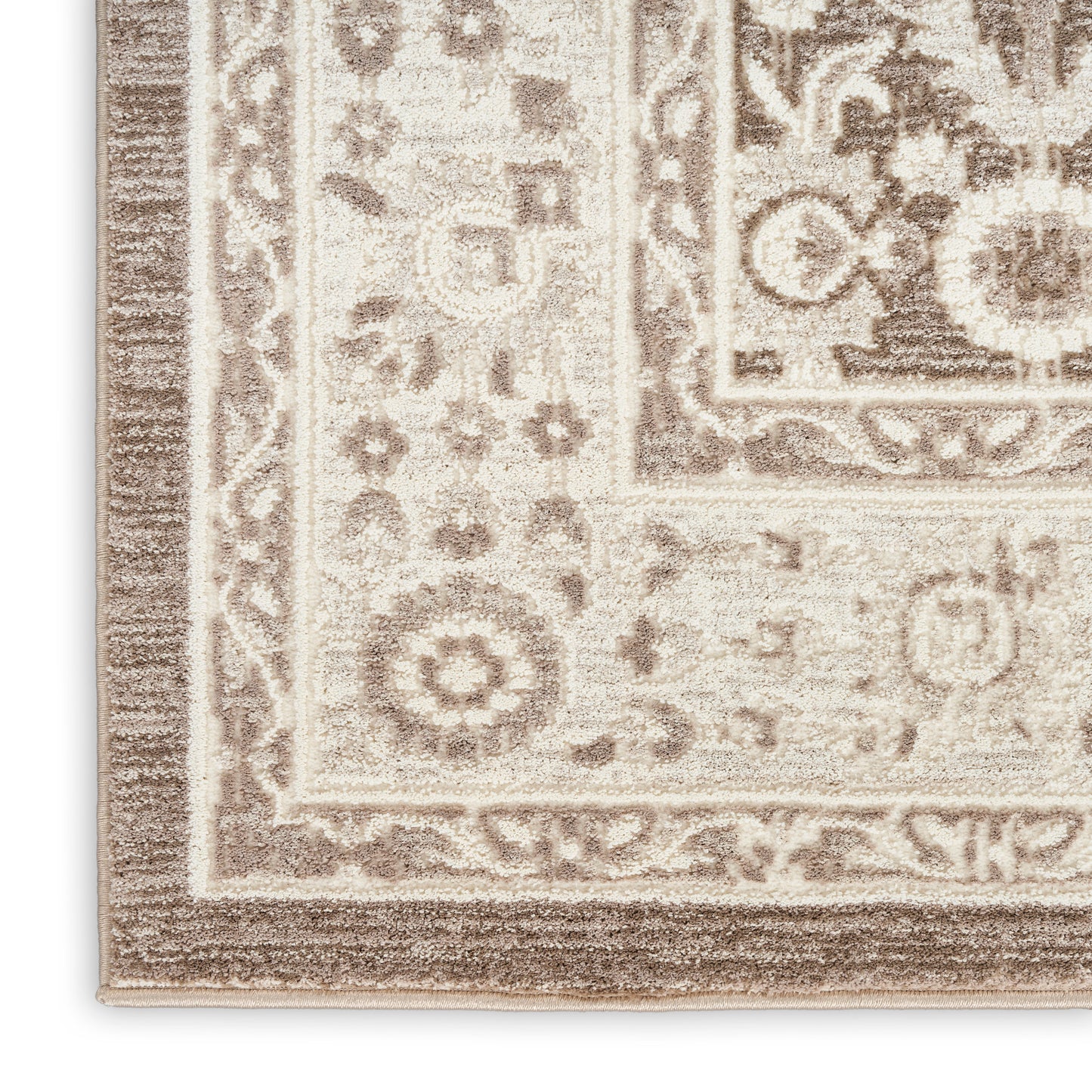 Beige-taupe oriental rug corner with decorative floral border and medallion motif; woven, soft textured pile.