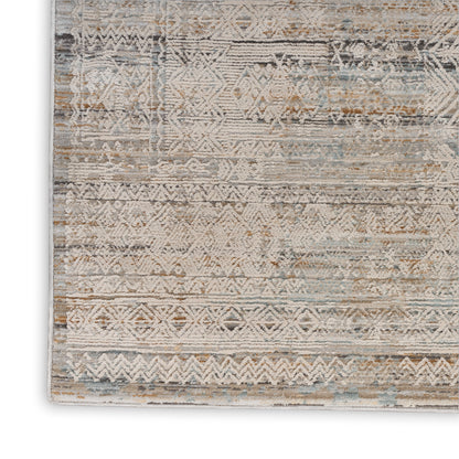 Distressed geometric rug in beige, ivory, taupe and dusty blue with tribal patterns.