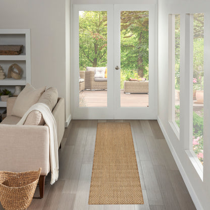 Bright living room with a narrow natural jute rug runner, beige sofa, white shelves, and glass doors opening to a patio.