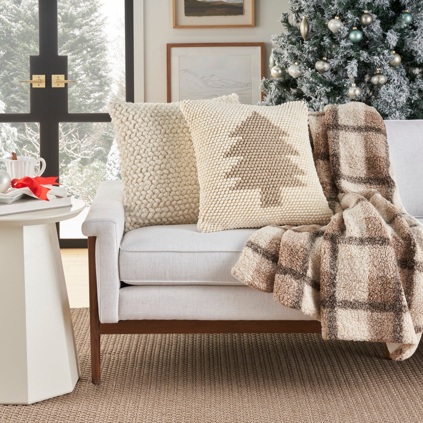Decorative ivory beige 20x20 pillow on a cream sofa with a knitted-tree pattern.