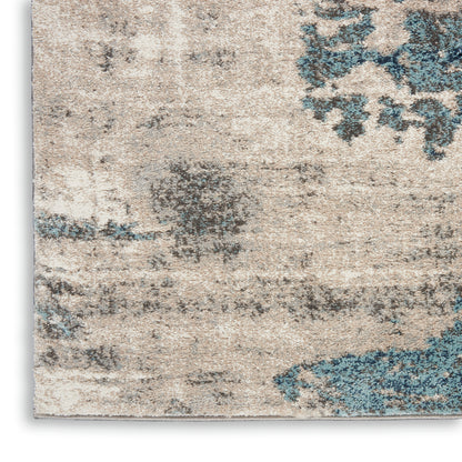 Beige distressed area rug with blue floral motifs and a textured woven pattern.