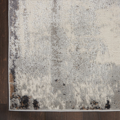 Muted gray and cream abstract rug with weathered pattern on dark wood floor; slim border.