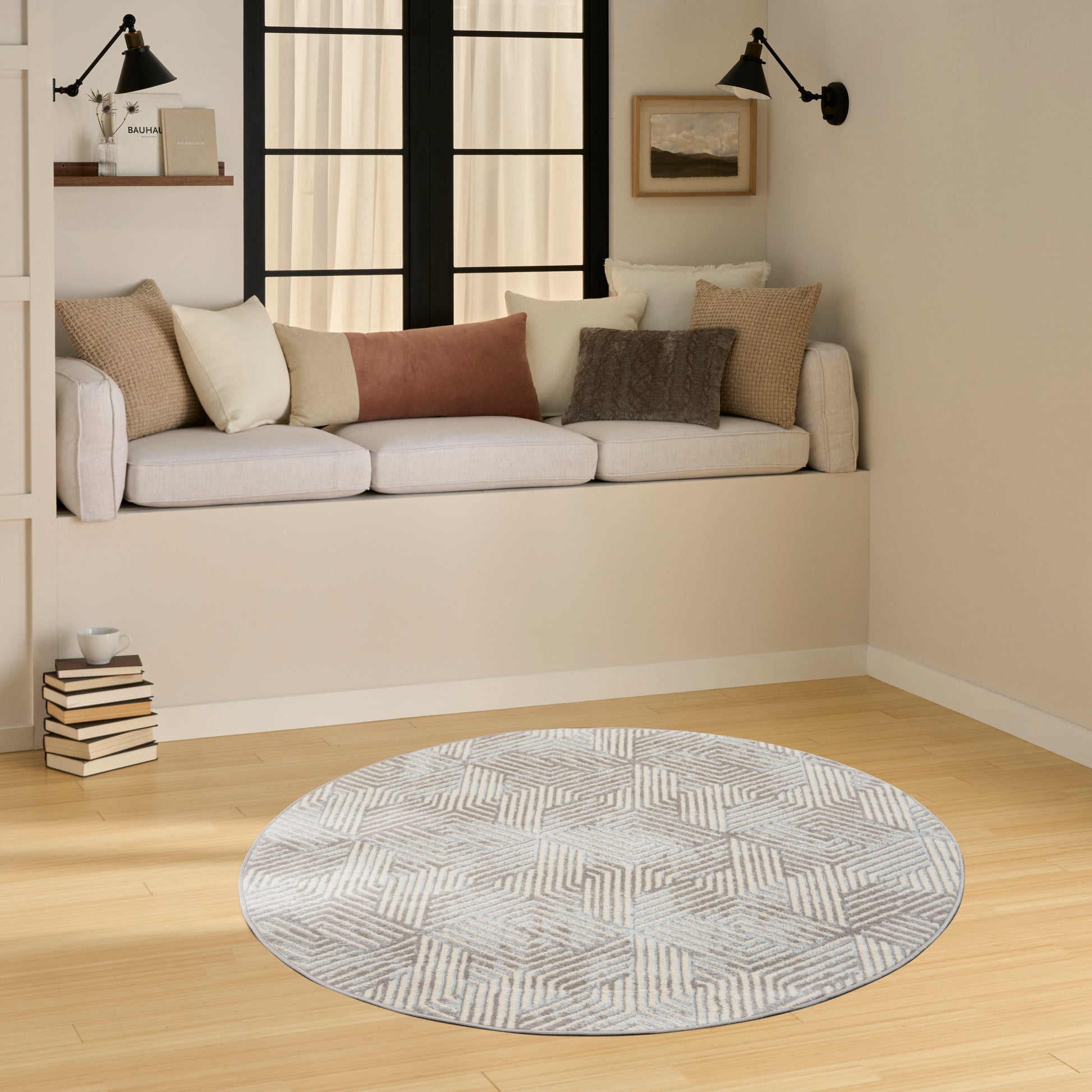 Cozy living room with a built-in window bench in light gray, multi-color throw pillows, and a round geometric gray rug.