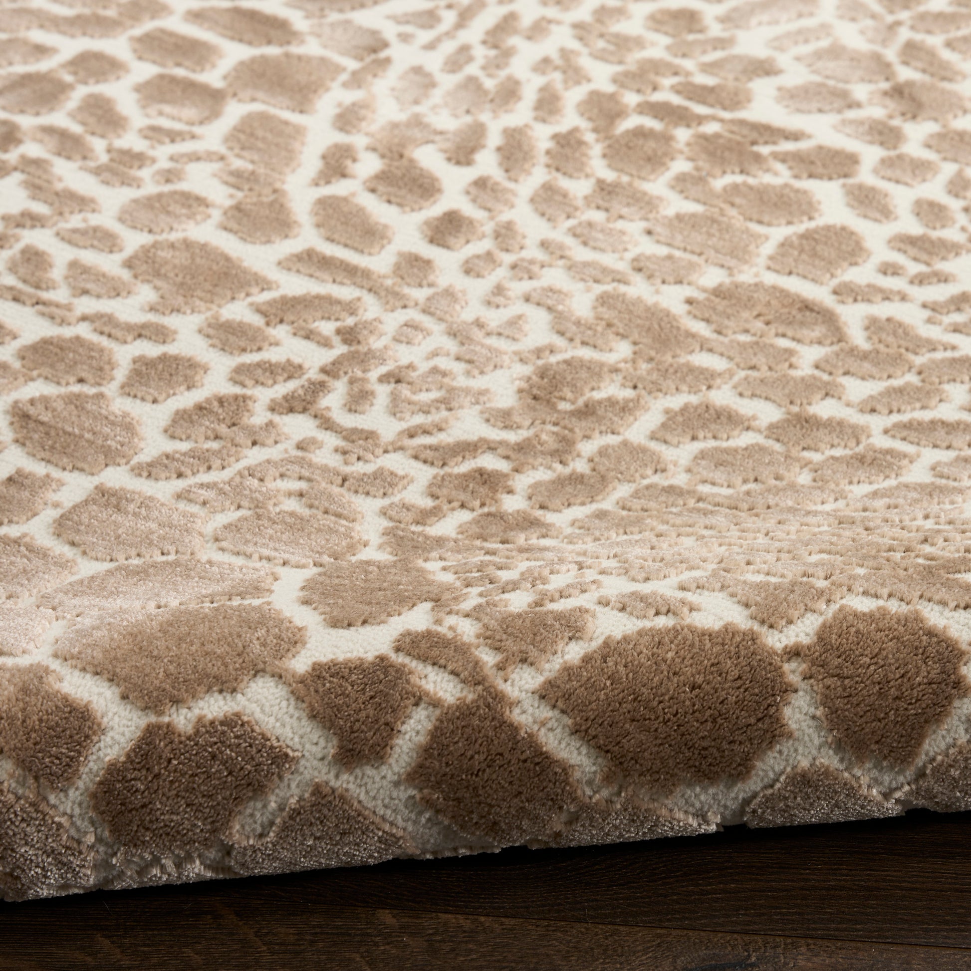 Beige leopard-pattern shag rug with plush pile on cream base, warm tan spots, ideal for living room on dark wood floor
