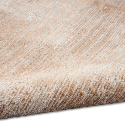 Beige textured area rug with soft plush pile and tan stripes; rolled edge visible, cozy home decor.