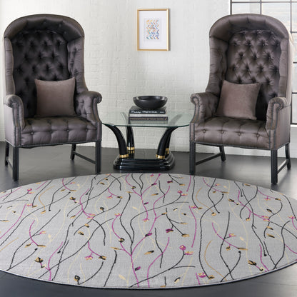 Round, light-patterned rug beneath two dark gray tufted leather club chairs with nailhead trim and a glass coffee table.