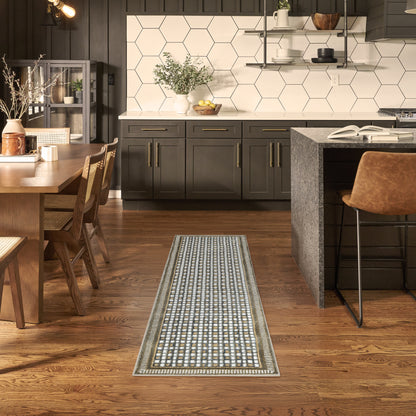 Dark kitchen with white hex tile backsplash, wooden dining table, island, and a blue-gray geometric runner rug.