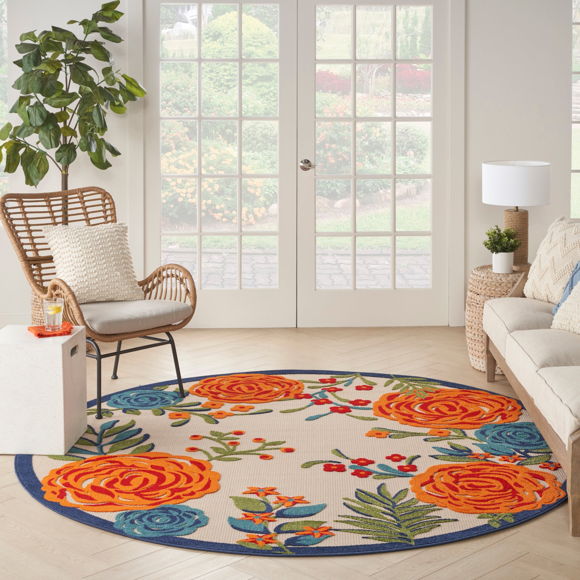 Round multicolor floral rug with orange roses, blue blossoms, green leaves and a blue border.