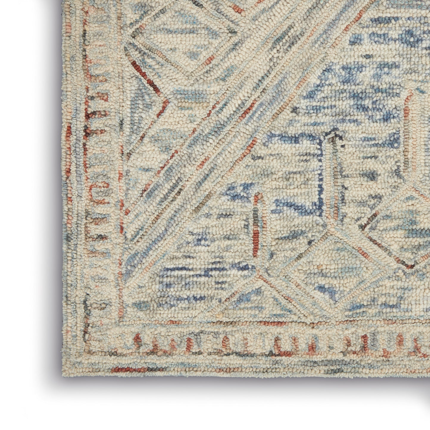 Cream and light blue rug corner with geometric lattice pattern, rust border, textured pile.