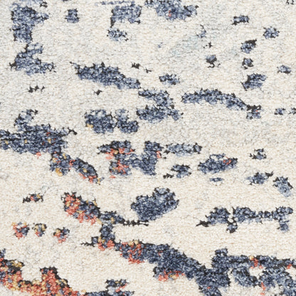 Beige shag rug with irregular navy blue and rust blotches; plush pile, abstract modern style.