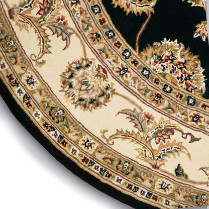 Round oriental rug with cream field, gold floral motifs and scrolling vines, black edge and decorative border.