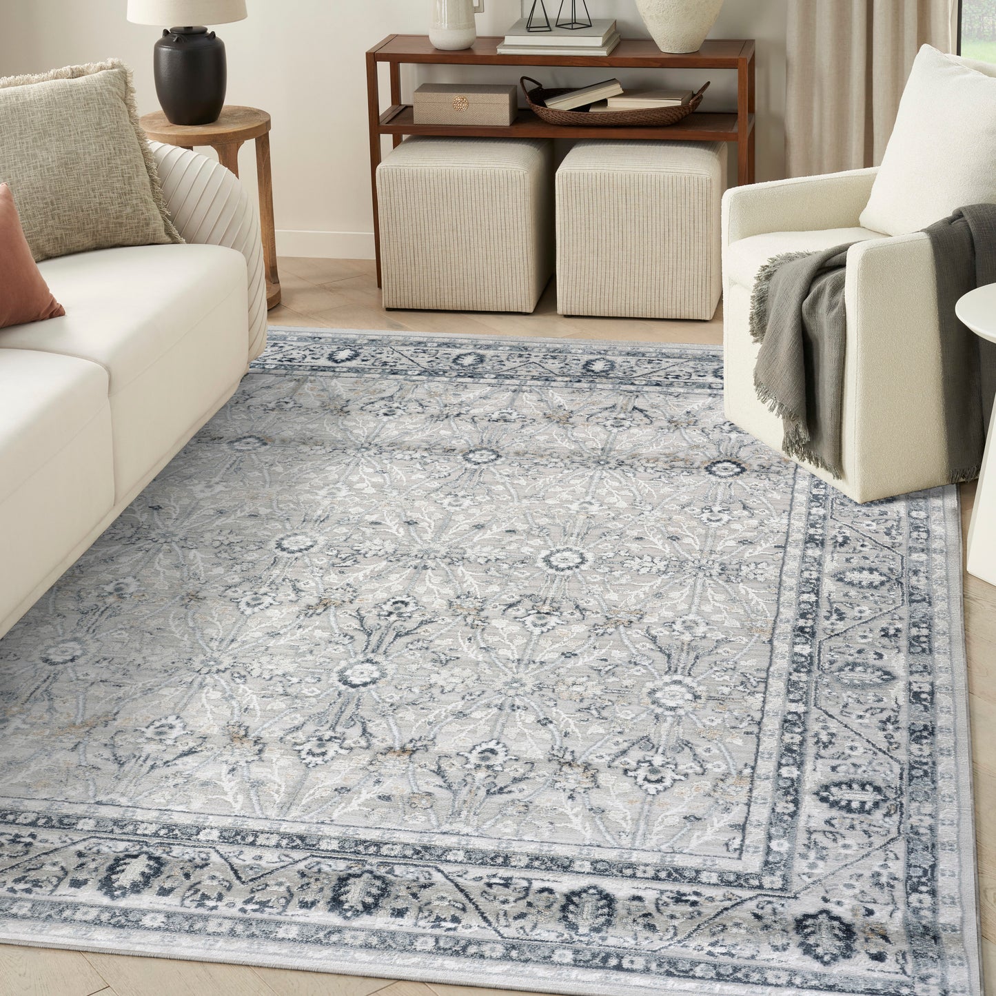 Blue-gray oriental area rug with floral medallions and border in a light living room with cream sofa.